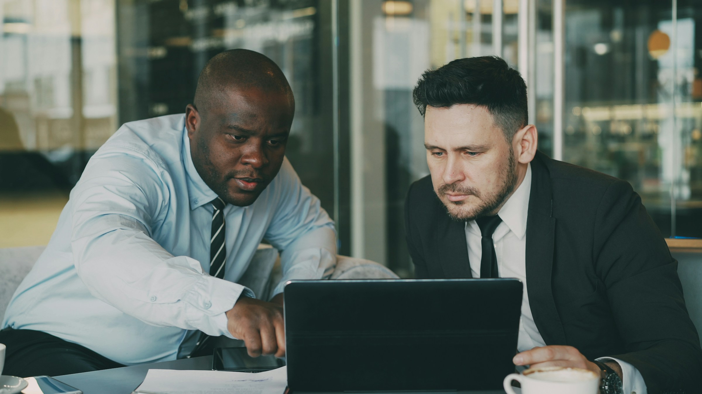 Two business colleagues reviewing a fractional CFO finance model on a laptop