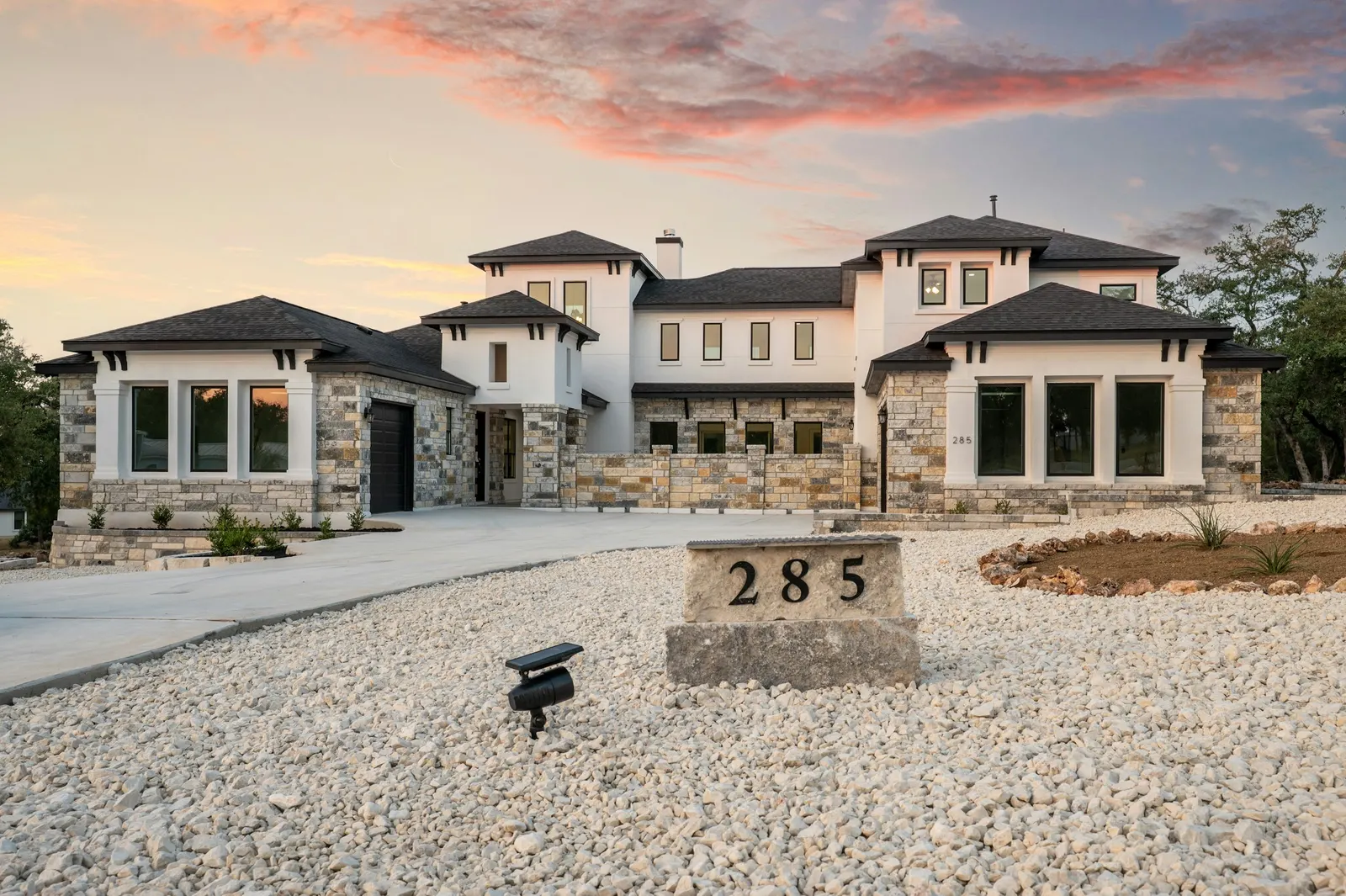 Stone and stucco Texas Hill Country home at sunset