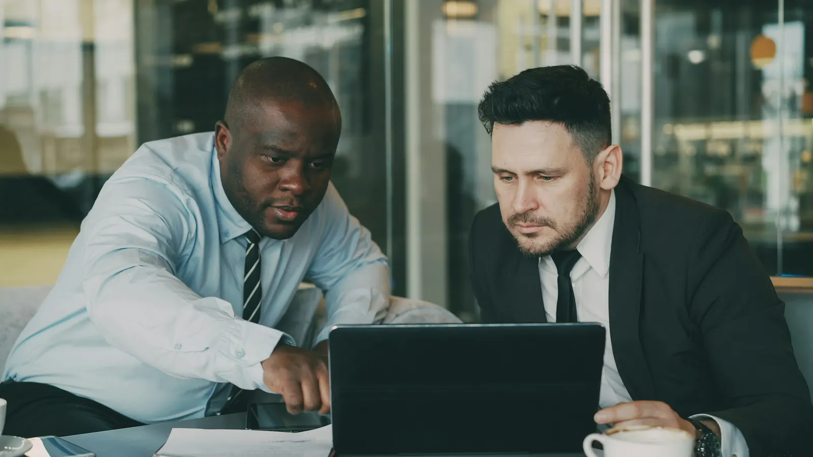 Two business colleagues reviewing a fractional CFO finance model on a laptop